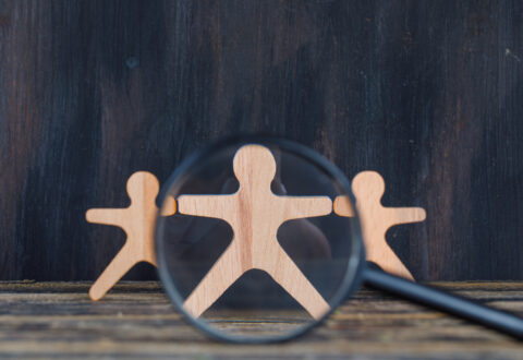 marketing-analysis-concept-with-magnifying-glass-wooden-figure-wooden-grunge-background-close-up